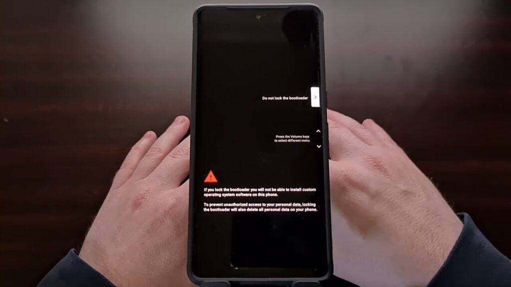 Google Pixel bootloader mode screen showing unlock warning and 'Do not lock the bootloader' option held in two hands.