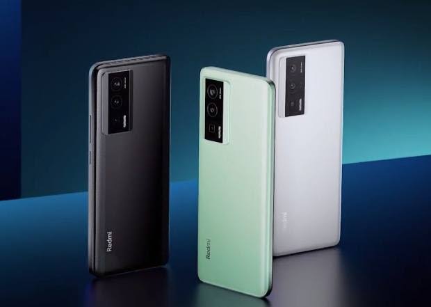 Redmi K60 Pro official product image showing three units in black, mint green, and white color variants, all displaying the rear camera module design against a dark blue studio background.